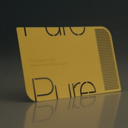 Gold brass business card with "Pure" logo. Luxury metal cards.