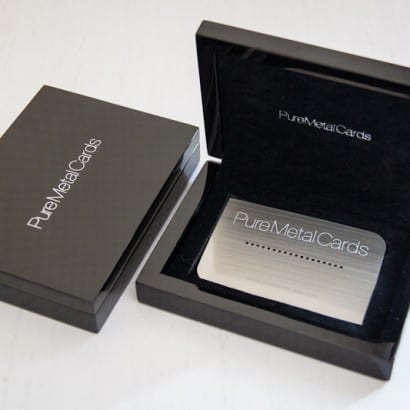Luxury black case displaying premium metal membership cards. PureMetalCards branding visible.