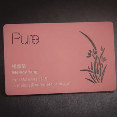 Pink metal business card with laser-cut floral design. "Pure" and contact info are visible.