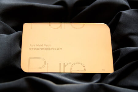 Elegant gold business card with "Pure" logo and website address.
