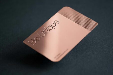 Rose gold mirror business card with "Be Unique" engraved.
