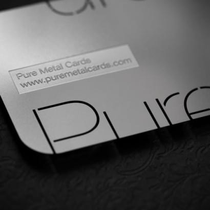 Close-up of sleek silver cards with "Pure Metal Cards" and website address.