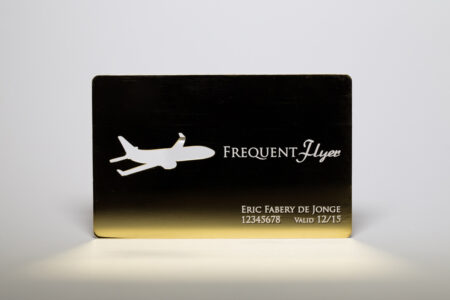 Gold-plated frequent flyer card with airplane cutout. Eric Fabery de Jonge, 12345678, Valid 12/15