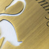 Close-up of antique brass flamingo design with "King's Club" engraved.
