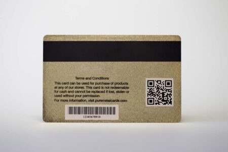 Back of brass (gold) frosted gift card showing terms, conditions, barcode, and QR code.