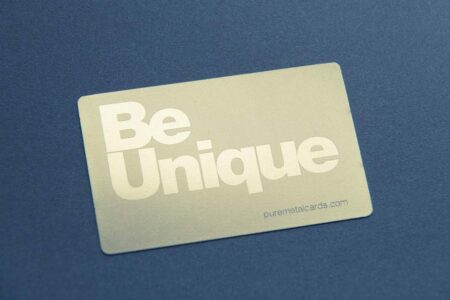 Gold metal card with "Be Unique" text. Brass prism card example.