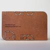 Copper frosted business card with "Pure" cut out. Pure Metal Cards website shown.