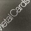Close-up of "MetalCards" text on a matt black frosted stainless steel surface.