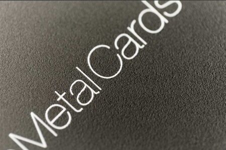 Close-up of "MetalCards" text on a matt black frosted stainless steel surface.