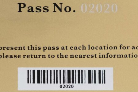 Close-up of a standard brass gold card, Pass No. 02020, with barcode.