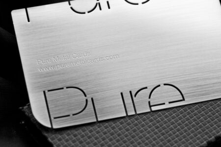 Close-up of brushed stainless steel business card; Pure Metal Cards website address.