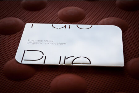 Sleek mirror stainless steel business card with "Pure Metal Cards" logo.