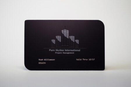 Matt black stainless steel business card with embossed logo and contact info.