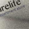 Close-up of frosted stainless steel with "Purelife department store" text.