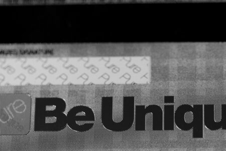 Close-up of a silver prism stainless steel card, showcasing the words "Be Unique".