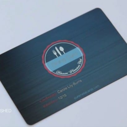 Matt black brushed metal business card featuring "Dinner's Premium Club" logo and contact info.