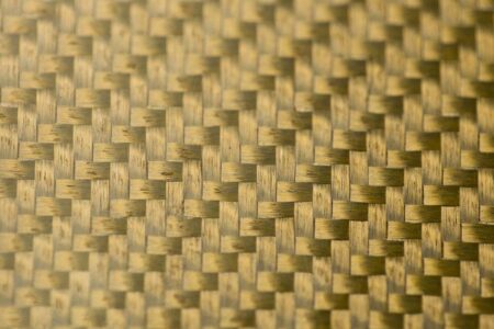 Close-up of gold glass fiber fabric with a woven texture.