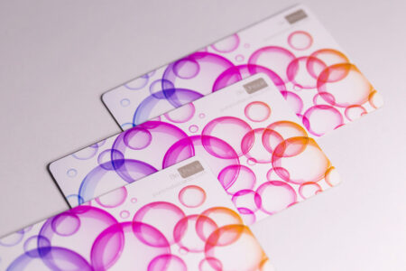 Three stainless steel white business cards with a bubble design. "Be Unique" is visible.