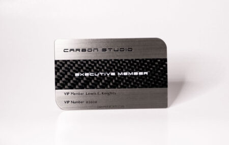 Brushed stainless steel business card with carbon fiber inlay. "Executive Member" and VIP details are visible.