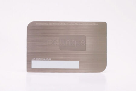 Brushed stainless steel business card with carbon fiber insert; "Be Unique" logo.