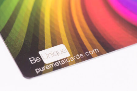 Close-up of metallic full color business cards; "Be Unique" and puremetalcards.com