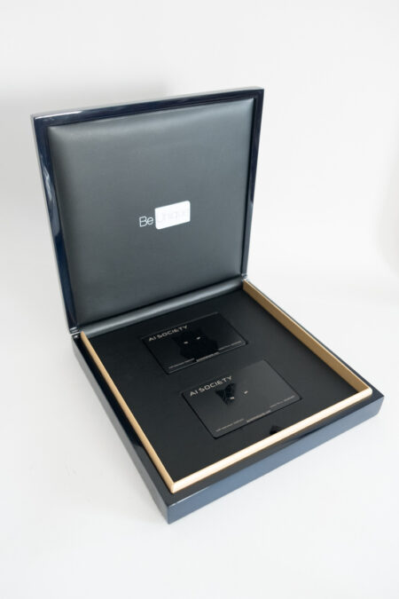 Luxury gift box containing two sleek black titanium cards. "AI Society" is printed on the cards.