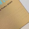 Pure_Metal_Cards_brass_contour_gold_member_card_02 Close-up of elegant gold brass contour business cards with embossed text. Valid Thru: 2020.