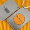 Two brushed metal RFID/NFC cards; one is a keychain. "Be Unique" is engraved on both.