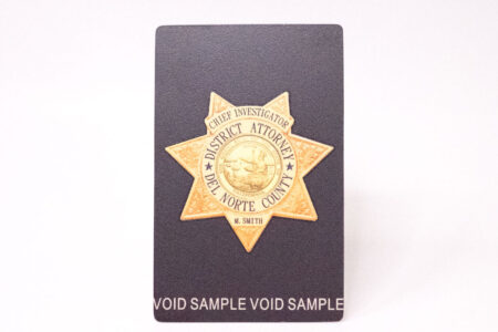 Close-up of a Del Norte County District Attorney's metal ID badge.