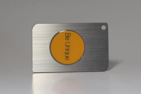 Silver RFID/NFC card with orange "Be Unique" circle.