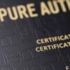 Close-up of elegant matt black brass cards with "Pure Authentic" and certificate details embossed.