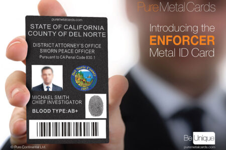 Close-up of a hand holding a black metal Enforcer ID card; "State of California" and "Chief Investigator" are visible.