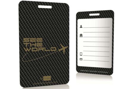Two sleek carbon fiber luggage tags; one features "See the World" text, the other is blank for personalization.