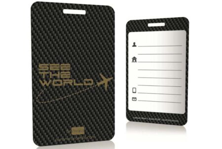 Pure-Metal-Cards-carbon-fiber-luggage-tag-1 Two sleek carbon fiber luggage tags; one features "See the World" text, the other is blank for personalization.