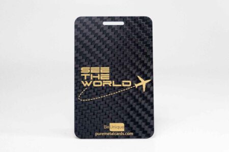 Black carbon fiber luggage tag with "See the World" and airplane graphic.