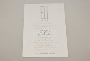 Elegant metal invitation card for Eli's Bar Mitzvah, featuring Hebrew text and event details.