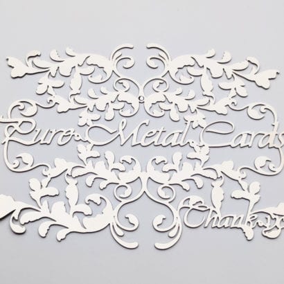 Intricate metal invitation cards with floral design. "Pure Metal Cards, Thank You.