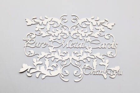 Intricate metal invitation cards with floral design. "Pure Metal Cards, Thank You.