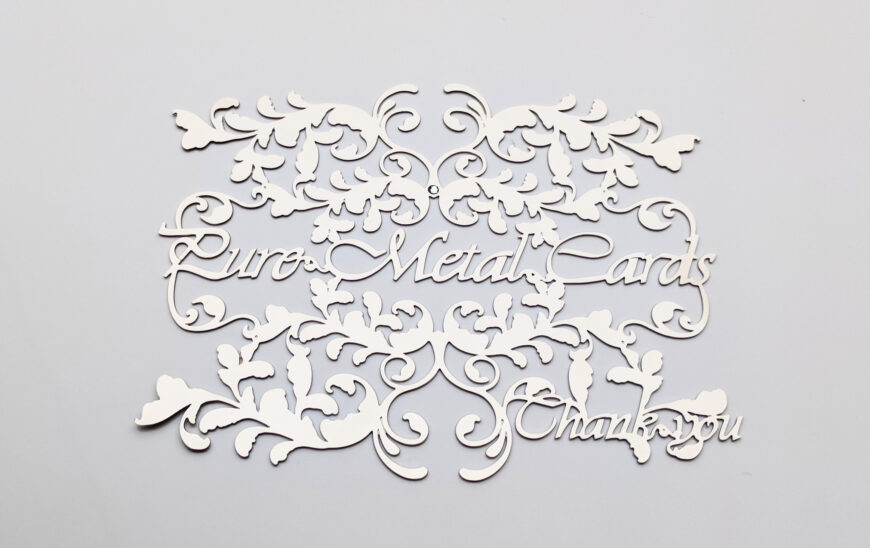 Intricate metal invitation cards with floral design. "Pure Metal Cards, Thank You.