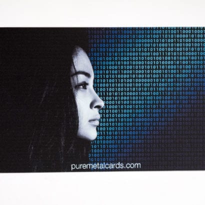 Close-up of a color photo metal card featuring a woman's profile and binary code. puremetalcards.com