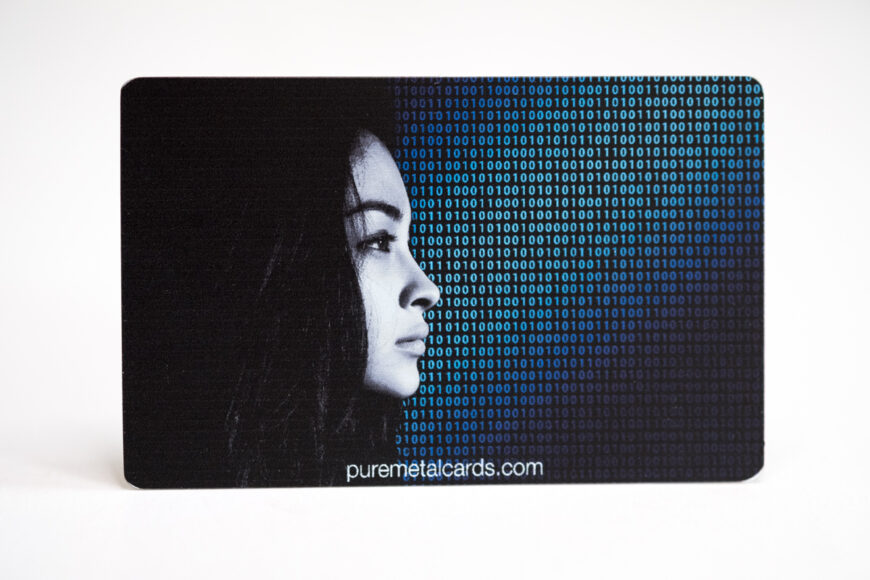 Close-up of a color photo metal card featuring a woman's profile and binary code. puremetalcards.com