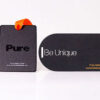 Two sleek black metal business cards; one rectangular, one rounded. Text includes "Pure" and "Be Unique".