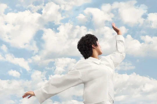 Person in white outfit against a cloudy sky, showcasing the Pantone 2026 Color Of The Year inspiration.
