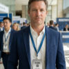 Man wearing a metal badge at a conference. Badge says "Nathan Park.