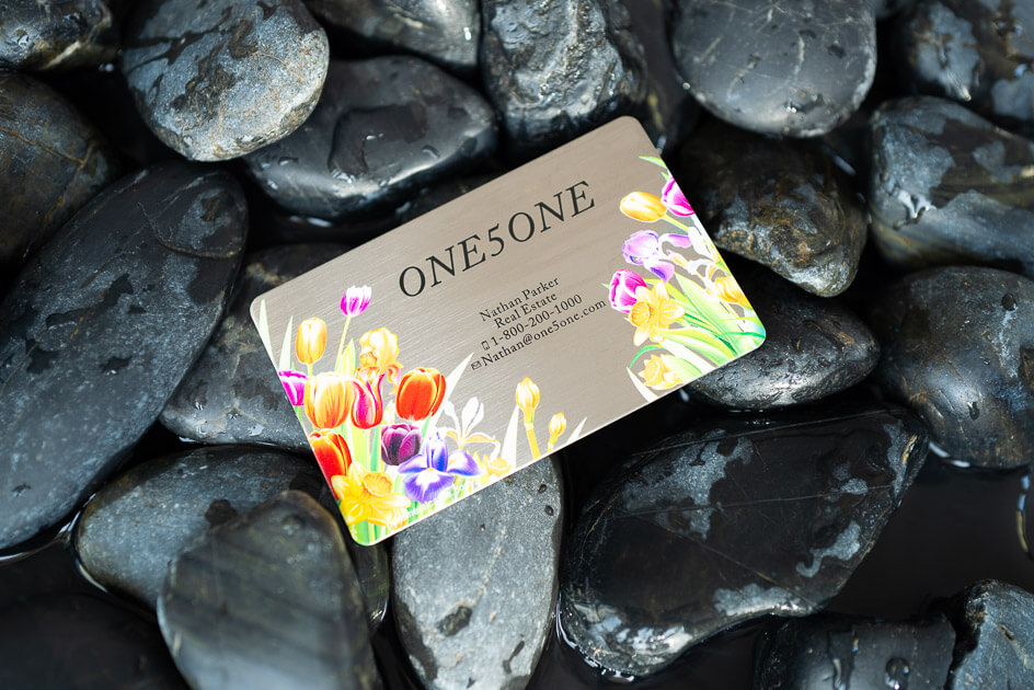 Sleek metal business card with floral design; features company name ONE5ONE and contact info. Metal business cards.