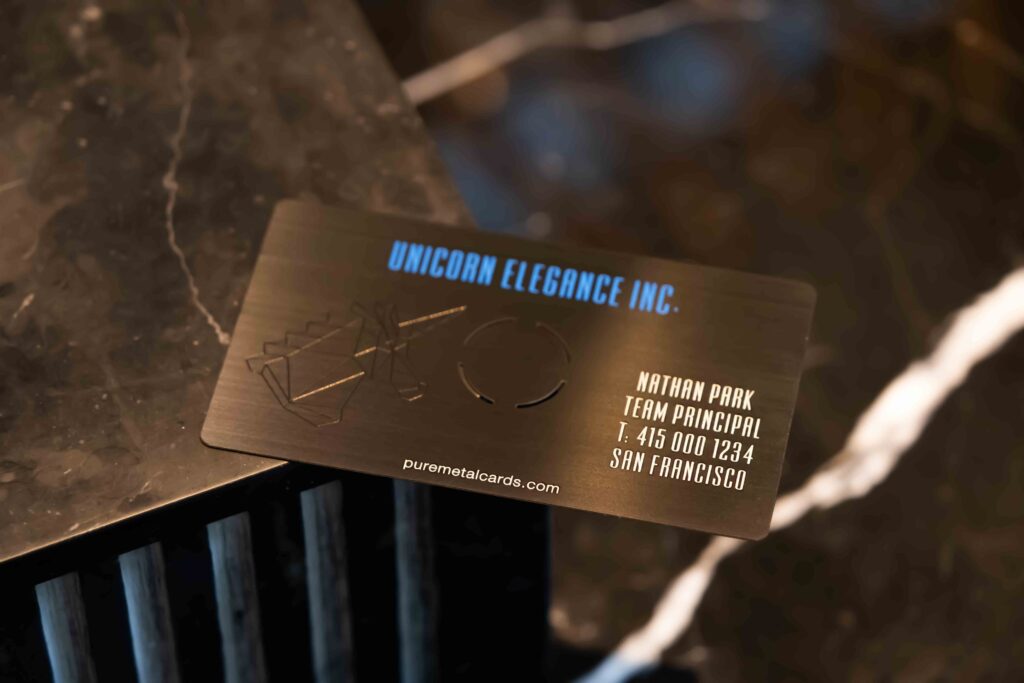 Metal business card with "UNICORN ELEGANCE INC." and contact info. Learn about metal business card size.