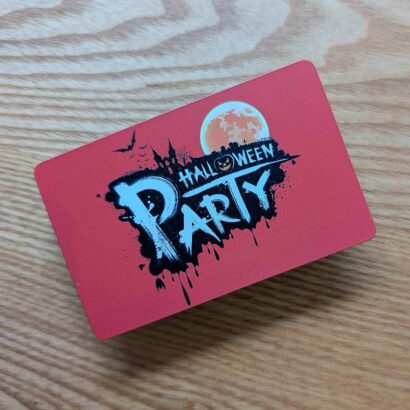 Red Halloween party invitation on a wood surface. "Halloween Party