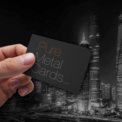 Hand holding a black Pure Metal Cards business card. Ultimate networking tool.