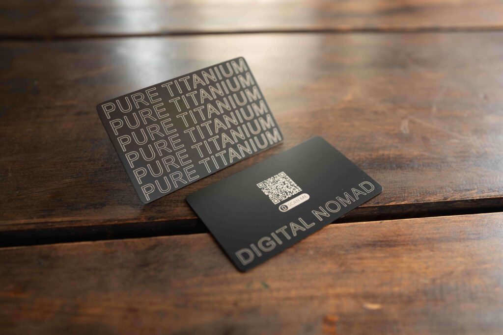 Metal business cards: One with "PURE TITANIUM" and the other with a QR code and "DIGITAL NOMAD.