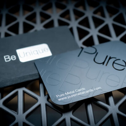 Black metal business card with "Pure" text on a dark mesh surface